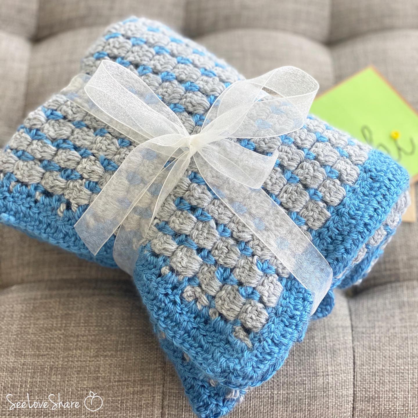 Finished block stitch blanket draped to show texture and two-color design