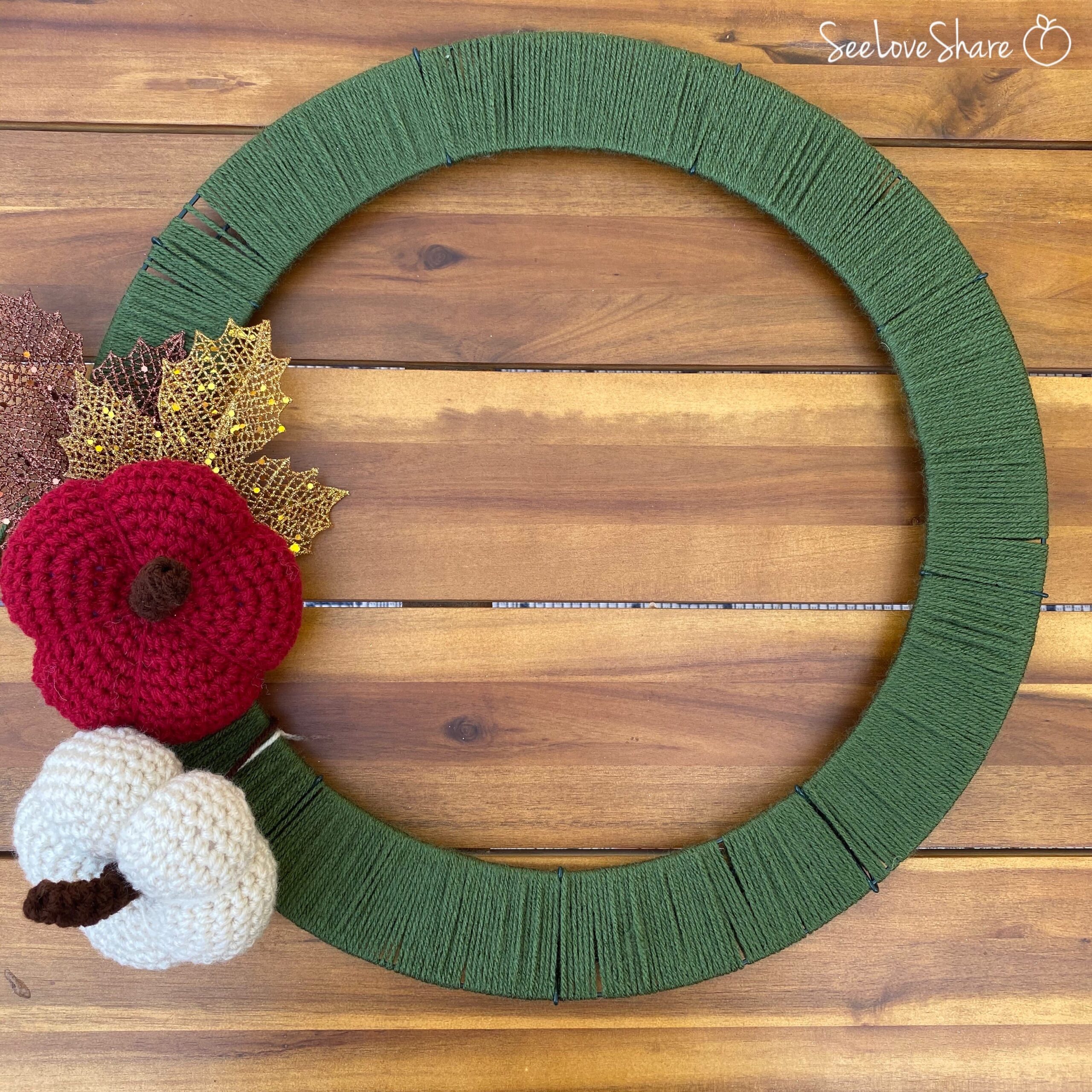 Test layout of mini crochet pumpkins on the wreath frame before attaching