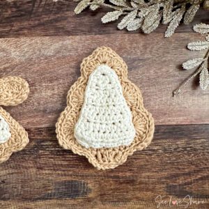 Crochet Christmas tree sugar cookie ornament with white frosting edging