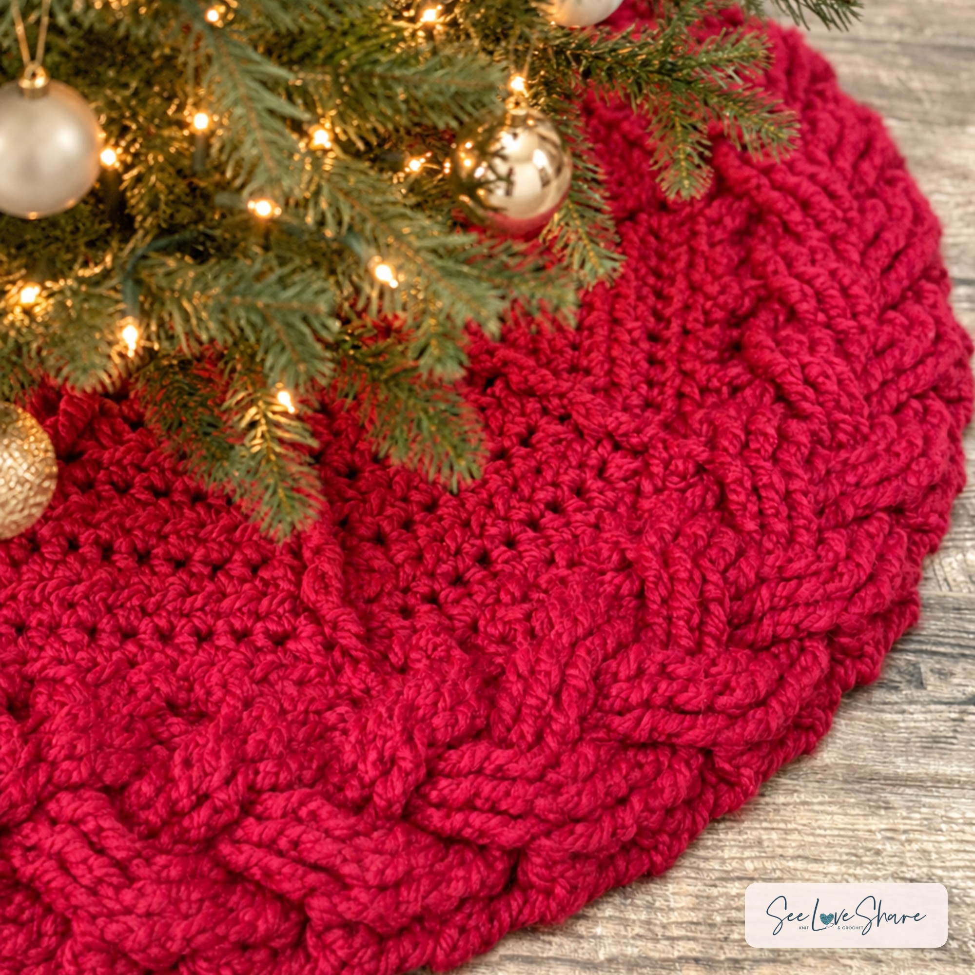 crochet tree skirt pattern in cranberry red with a chunky cable braid border under a lit Christmas tree